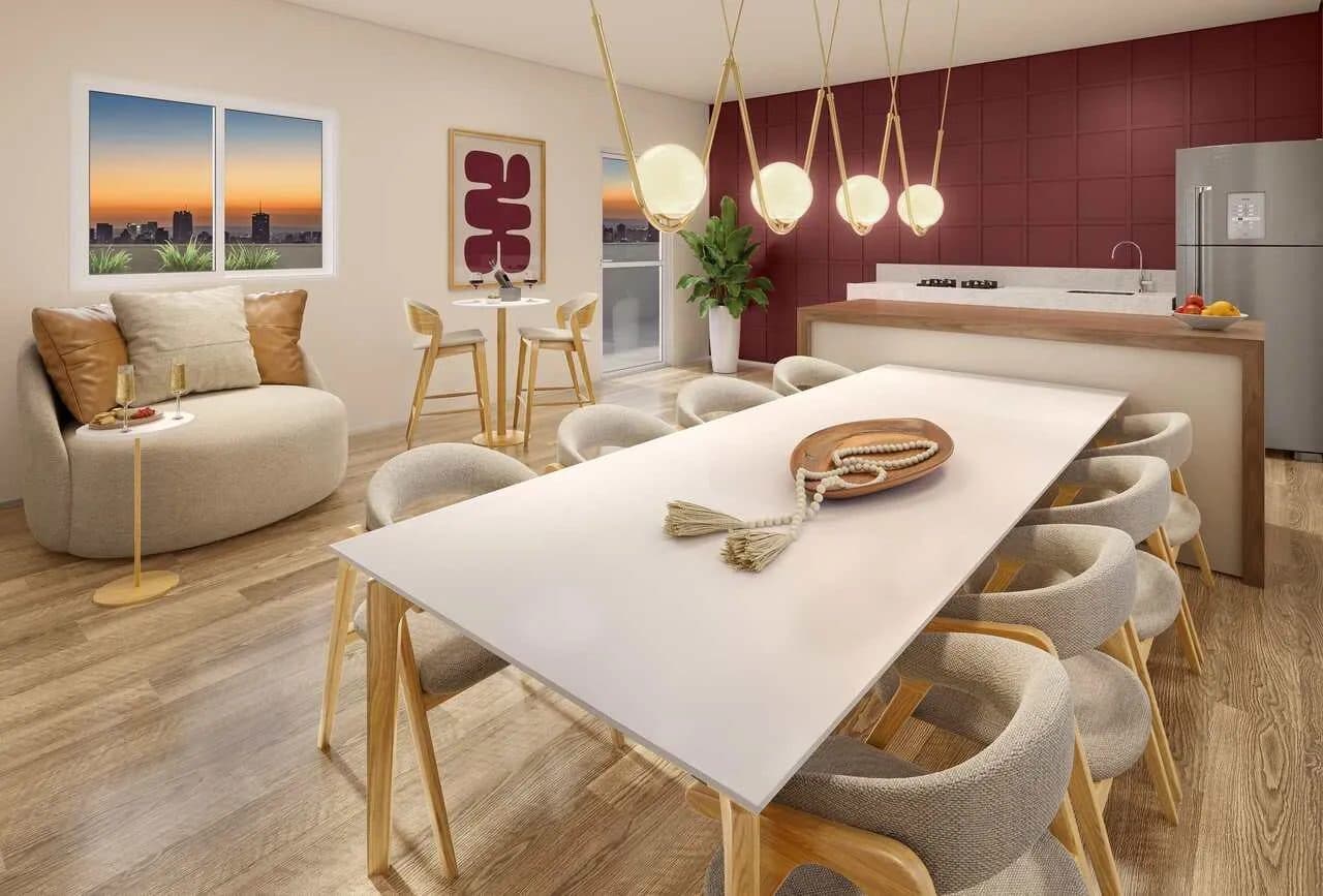 Ambiente integrado de estar e jantar com mesa ampla, cadeiras e cozinha ao fundo